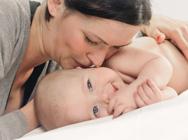 Mutlu bebek yanağından öpüyor anne — Stok fotoğraf
