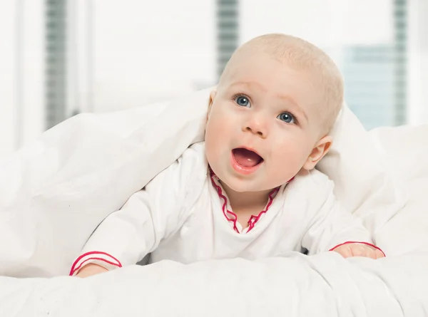 Menina bebê deitado sob cobertor branco — Fotografia de Stock