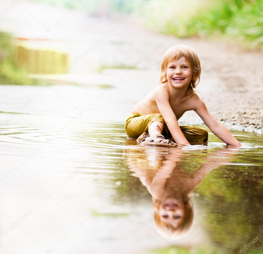 boy sitting in puddle