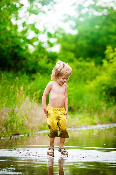 泥の水たまりの少年 — ストック写真