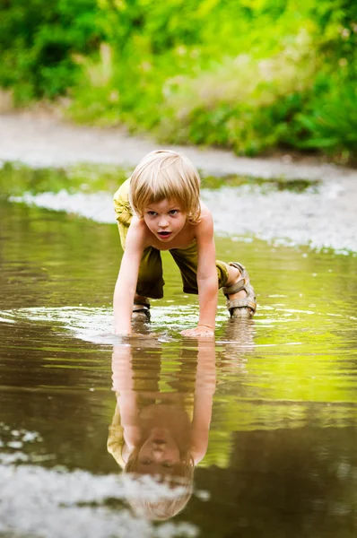 Boy playing in puddle — Stock Photo, Image