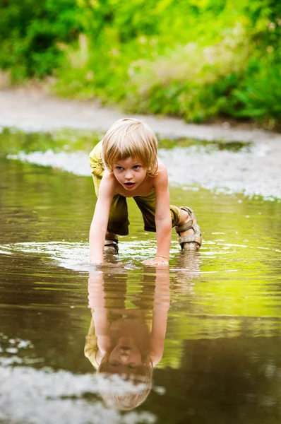 Niño jugando en charco —  Fotos de Stock