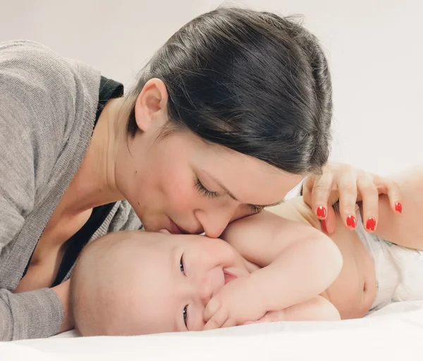 Mutter küsst glückliches Baby auf Wange — Stockfoto