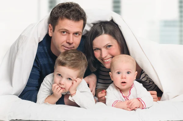 ベッドで子供と幸せな家族 — ストック写真