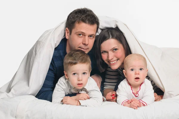 Счастливая семья с детьми в постели — стоковое фото