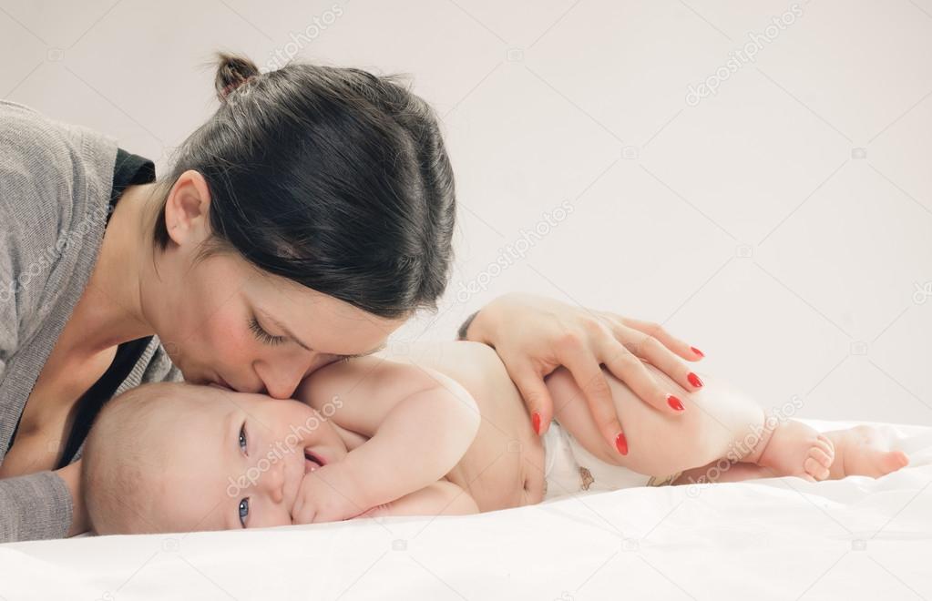 Mother kissing happy baby on cheek