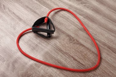 Ahşap zemin üzerinde kalp şeklinde kırmızı elastik genişletici