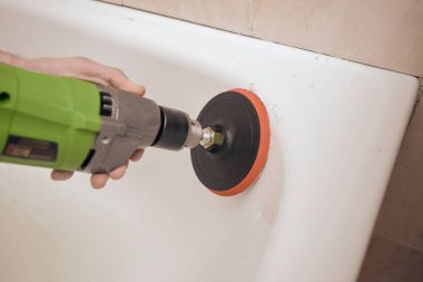 Yenilenmeden önce küvetin yüzeyini öğüten adama yakın çekim