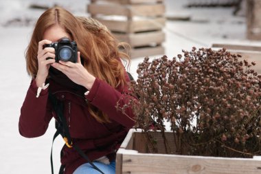 Genç bayan fotoğrafçı açık havada fotoğraf çekimi yapıyor.
