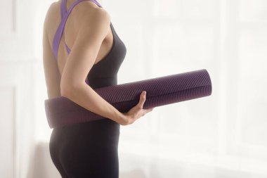 Spor salonunda spor paspası olan atletik bir kadının yakın plan fotoğrafı.