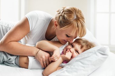 Kadın ve kızı yatak gülümseyen yalan