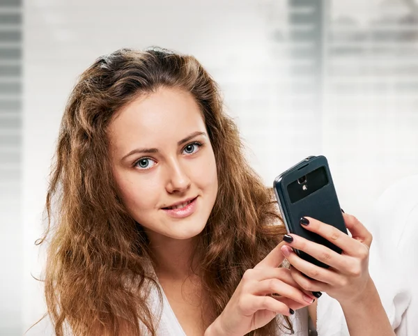 Strahlende Frau mit Handy im Bett liegend — Stockfoto