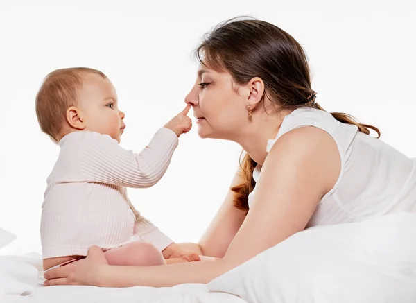 Kvinna och dotter spelar i sängen — Stockfoto