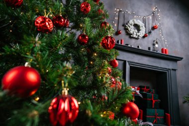 2021 yılının içinde mumlar, ampuller ve bokeh ile. Noel kutlaması için dekore edilmiş bir oda. Hediyeli Noel ağacı