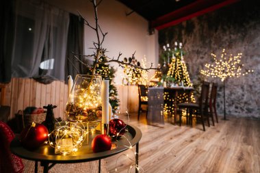 2021 yılının içinde mumlar, ampuller ve bokeh ile. Noel kutlaması için dekore edilmiş bir oda. Hediyeli Noel ağacı