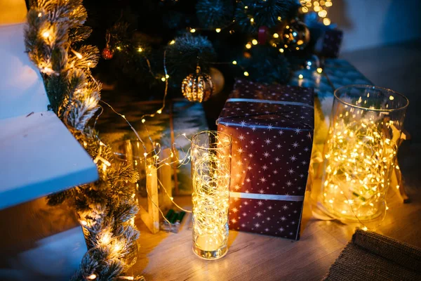2021 yılının içinde mumlar, ampuller ve bokeh ile. Noel kutlaması için dekore edilmiş bir oda. Hediyeli Noel ağacı