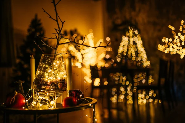 2021 yılının içinde mumlar, ampuller ve bokeh ile. Noel kutlaması için dekore edilmiş bir oda. Hediyeli Noel ağacı