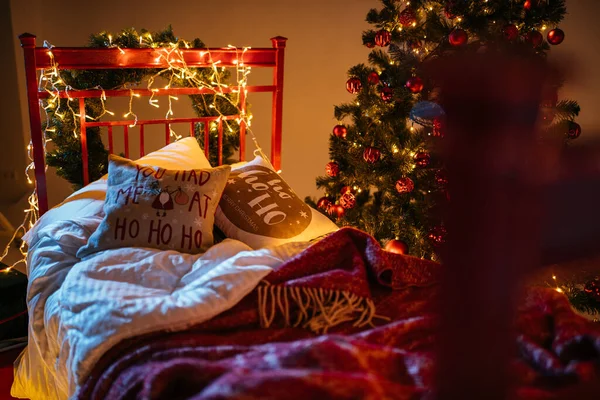 2021 yılının içinde mumlar, ampuller ve bokeh ile. Noel kutlaması için dekore edilmiş bir oda. Hediyeli Noel ağacı