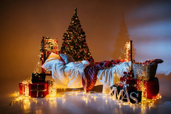 2021 yılının içinde mumlar, ampuller ve bokeh ile. Noel kutlaması için dekore edilmiş bir oda. Hediyeli Noel ağacı
