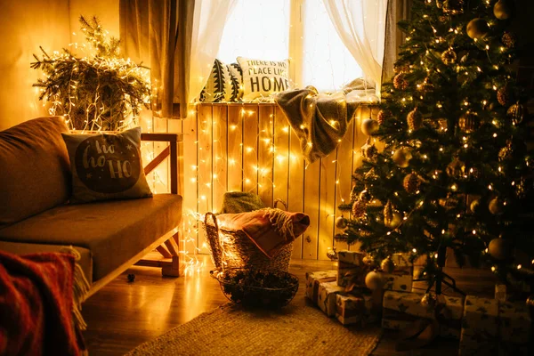 2021 yılının içinde mumlar, ampuller ve bokeh ile. Noel kutlaması için dekore edilmiş bir oda. Hediyeli Noel ağacı