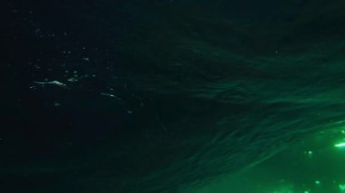 Ağır çekim su altında. Güneşli bir yaz akşamında dev bir turkuaz fıçı dalgası kameranın üzerinde kırılıyor. Altın gün batımında okyanus dalgalarının berrak görüntüsü. Yakın okyanus dalgalarının sineması.