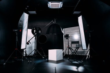 Kristal Beyaz oda siklonaması. Tam bir kara siklonama. Profesyonel ekipmanlı modern fotoğraf stüdyosu. Işık ekipmanlı boş fotoğraf stüdyosu. Yönetmen prodüksiyon koltuğuyla modern fotoğraf stüdyosunun içi..