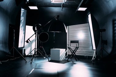 Kristal Beyaz oda siklonaması. Tam bir kara siklonama. Profesyonel ekipmanlı modern fotoğraf stüdyosu. Işık ekipmanlı boş fotoğraf stüdyosu. Yönetmen prodüksiyon koltuğuyla modern fotoğraf stüdyosunun içi..