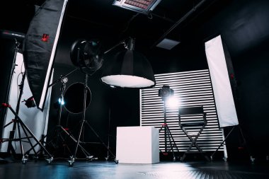 Kristal Beyaz oda siklonaması. Tam bir kara siklonama. Profesyonel ekipmanlı modern fotoğraf stüdyosu. Işık ekipmanlı boş fotoğraf stüdyosu. Yönetmen prodüksiyon koltuğuyla modern fotoğraf stüdyosunun içi..