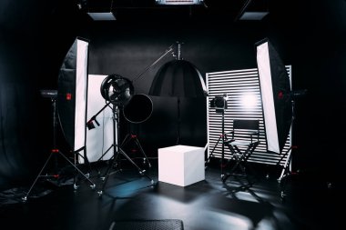 Kristal Beyaz oda siklonaması. Tam bir kara siklonama. Profesyonel ekipmanlı modern fotoğraf stüdyosu. Işık ekipmanlı boş fotoğraf stüdyosu. Yönetmen prodüksiyon koltuğuyla modern fotoğraf stüdyosunun içi..