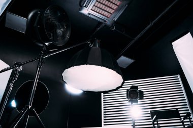 Kristal Beyaz oda siklonaması. Tam bir kara siklonama. Profesyonel ekipmanlı modern fotoğraf stüdyosu. Işık ekipmanlı boş fotoğraf stüdyosu. Yönetmen prodüksiyon koltuğuyla modern fotoğraf stüdyosunun içi..