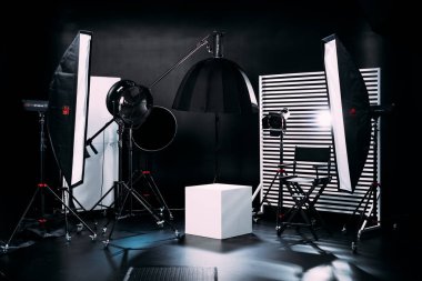 Kristal Beyaz oda siklonaması. Tam bir kara siklonama. Profesyonel ekipmanlı modern fotoğraf stüdyosu. Işık ekipmanlı boş fotoğraf stüdyosu. Yönetmen prodüksiyon koltuğuyla modern fotoğraf stüdyosunun içi..