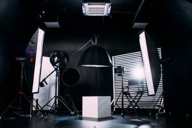 Kristal Beyaz oda siklonaması. Tam bir kara siklonama. Profesyonel ekipmanlı modern fotoğraf stüdyosu. Işık ekipmanlı boş fotoğraf stüdyosu. Yönetmen prodüksiyon koltuğuyla modern fotoğraf stüdyosunun içi..