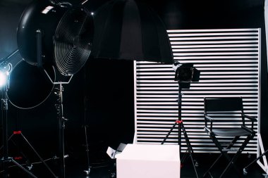 Kristal Beyaz oda siklonaması. Tam bir kara siklonama. Profesyonel ekipmanlı modern fotoğraf stüdyosu. Işık ekipmanlı boş fotoğraf stüdyosu. Yönetmen prodüksiyon koltuğuyla modern fotoğraf stüdyosunun içi..