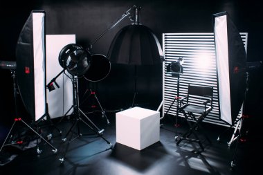 Kristal Beyaz oda siklonaması. Tam bir kara siklonama. Profesyonel ekipmanlı modern fotoğraf stüdyosu. Işık ekipmanlı boş fotoğraf stüdyosu. Yönetmen prodüksiyon koltuğuyla modern fotoğraf stüdyosunun içi..