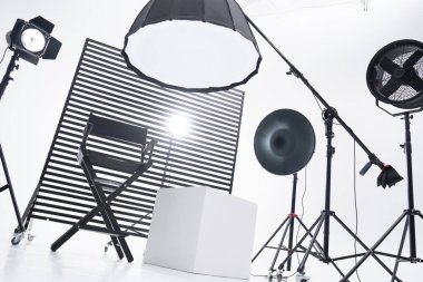Kristal Beyaz oda siklonaması. Tam bir kara siklonama. Profesyonel ekipmanlı modern fotoğraf stüdyosu. Işık ekipmanlı boş fotoğraf stüdyosu. Yönetmen prodüksiyon koltuğuyla modern fotoğraf stüdyosunun içi..