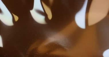 Eski film şeridi köpükle yanar. Plastik yanan baloncuklar 35 mm 'lik eski film şeridini yakar. Yanan baloncuklar izole edilir. Klasik film makarası, sinematik retro etkisi.