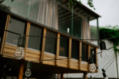 Balkonlu zarif ahşap ev terası. Banyo ve yatak odasının kapıları. Ahşap zeminli, mobilyalı ve muhteşem manzaralı geniş bir teras manzarası..