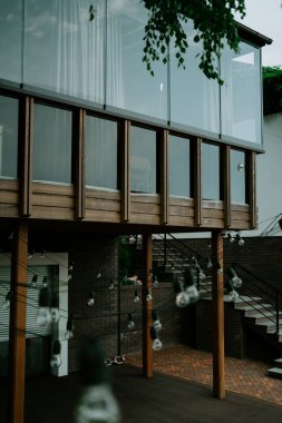 Balkonlu zarif ahşap ev terası. Banyo ve yatak odasının kapıları. Ahşap zeminli, mobilyalı ve muhteşem manzaralı geniş bir teras manzarası..