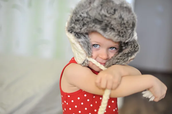 Baby girl with big blue eyes wearing a huge winter hat — Stock Photo, Image