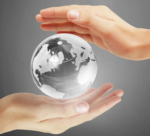 Глобус у людській руці, рука тримає нашу планету землею, що сяє. Вухо — стокове фото