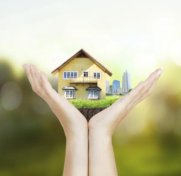 Huis in menselijke handen — Stockfoto