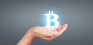 Eller bitcoin simgesini dijital üzerinde sanal para olarak gösterir