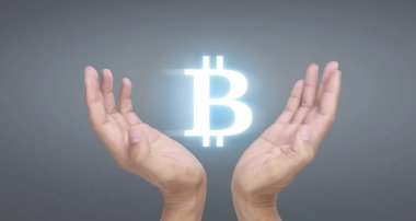Eller bitcoin simgesini dijital üzerinde sanal para olarak gösterir