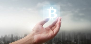 Eller bitcoin simgesini dijital üzerinde sanal para olarak gösterir