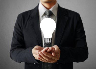 Elinde ampul tutan bir iş adamı.