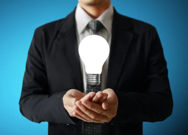 Businessman holding light bulb — Stock Photo, Image