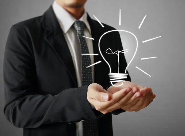 Businessman holding light bulb Stock Picture