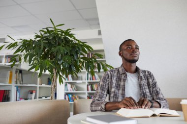 Kör Afro-Amerikalı bir adamın okul kütüphanesinde Braille kitabı okuması, kopyalaması...