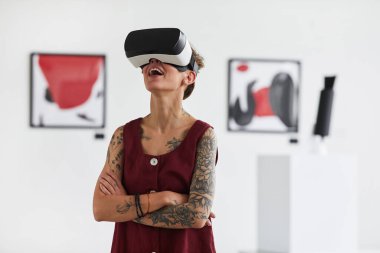 Modern sanat galerisi sergisi, fotokopi alanı gibi ilgi çekici deneyimleri olan dövmeli genç bir kadının belden yukarı portresi.