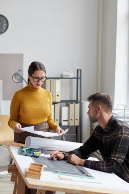 Ofiste birlikte çalışırken planlarını tartışan iki mimarın dikey portresi